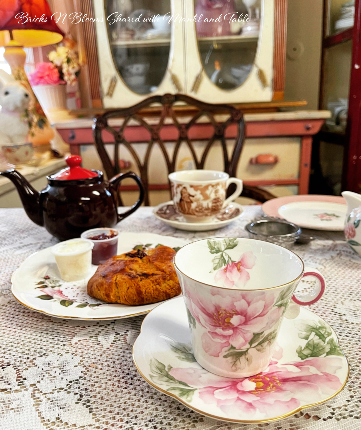 pink flowered teacup with scone at high tea