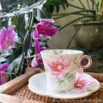 small photo of pink flowered teacup and purple orchid