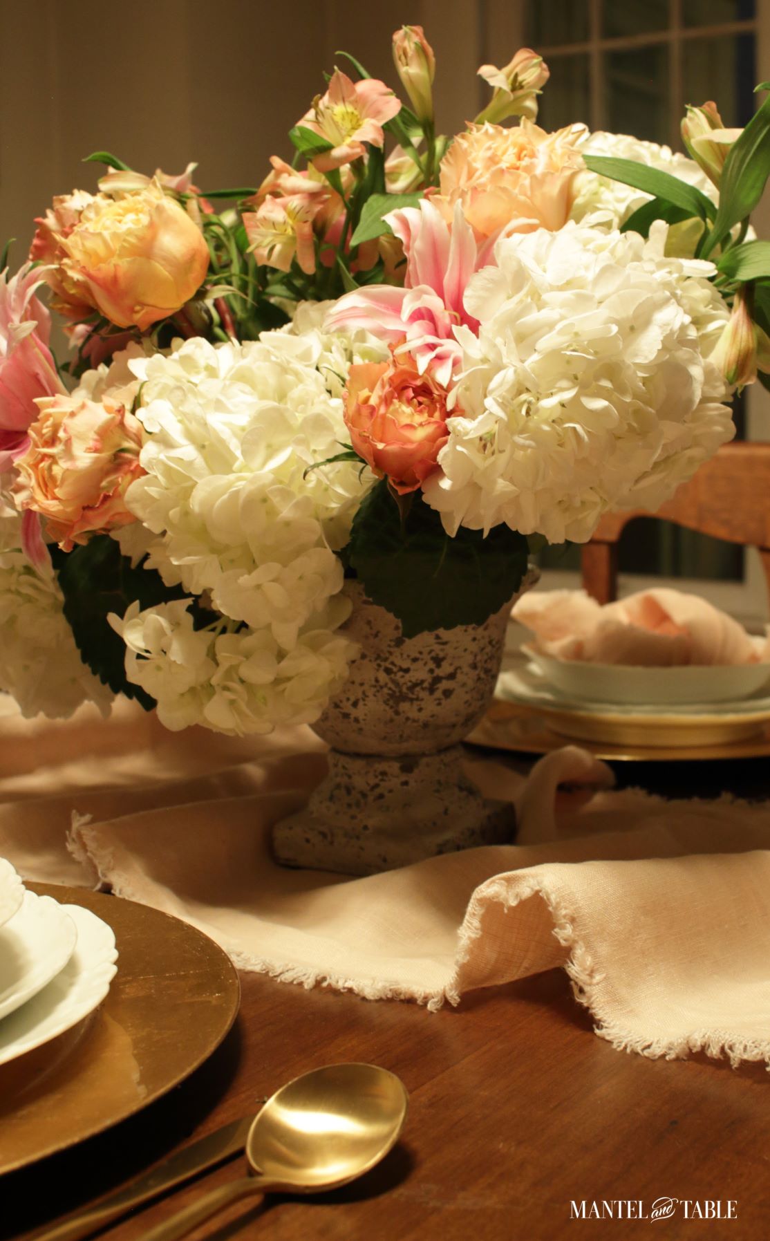 Closeup of small white textured urn centerpiece full of flowers