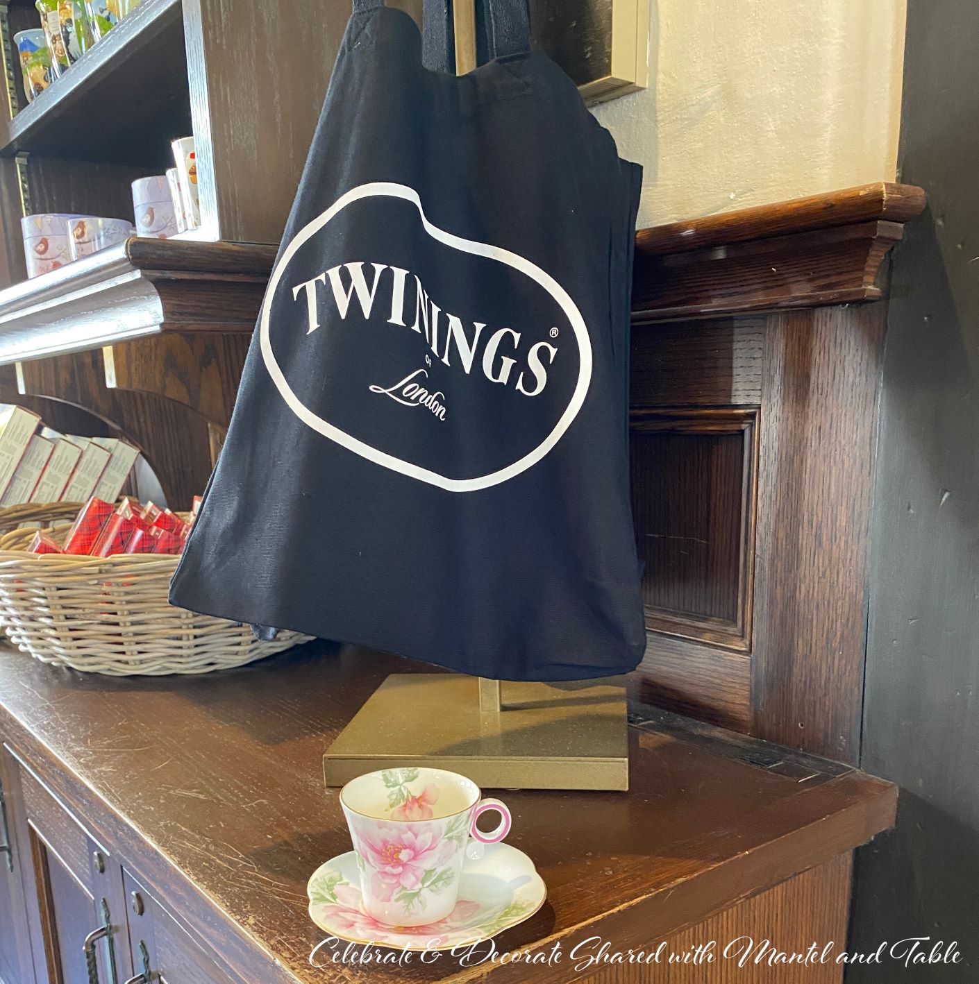 Tea at EPCOT - pink and white teacup on wooden counter in tea store. Twinings London bag hanging from gold stand