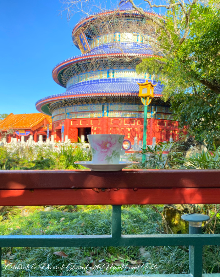 Pink and white teacup on red railing in front of China Pavilion at EPCOT
