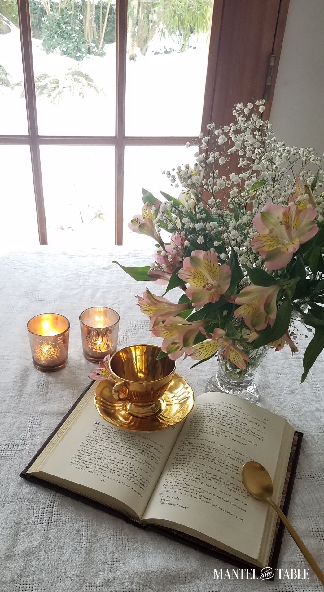 Gold teacup and saucer on table. Snowy outdoor view through window