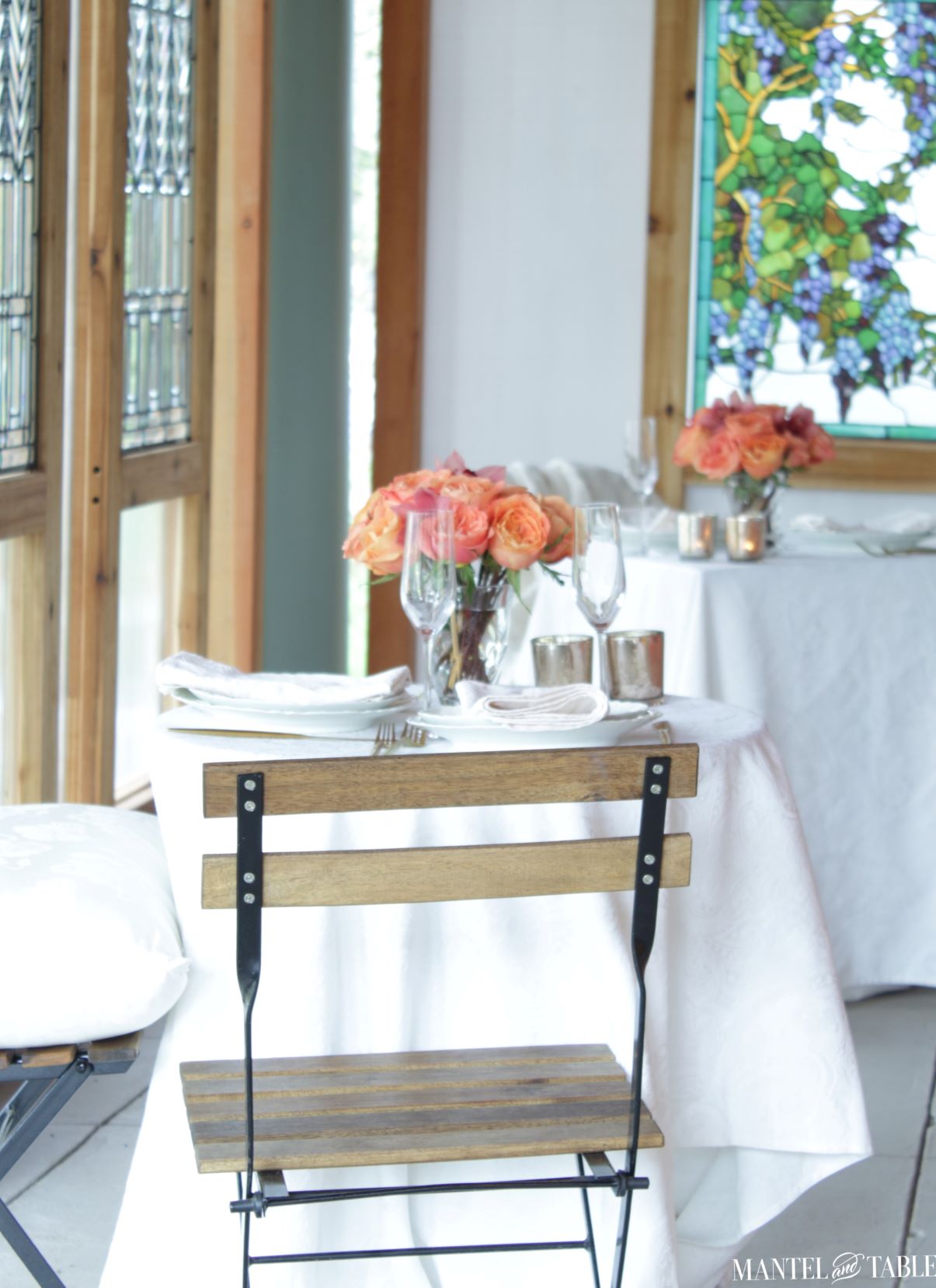 Socially distant tables with white cloths and peach flowers