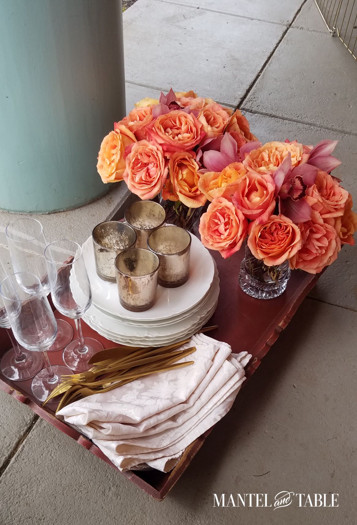 Flower arrangements, dishes, glasses, napkins, etc on tray on the porch