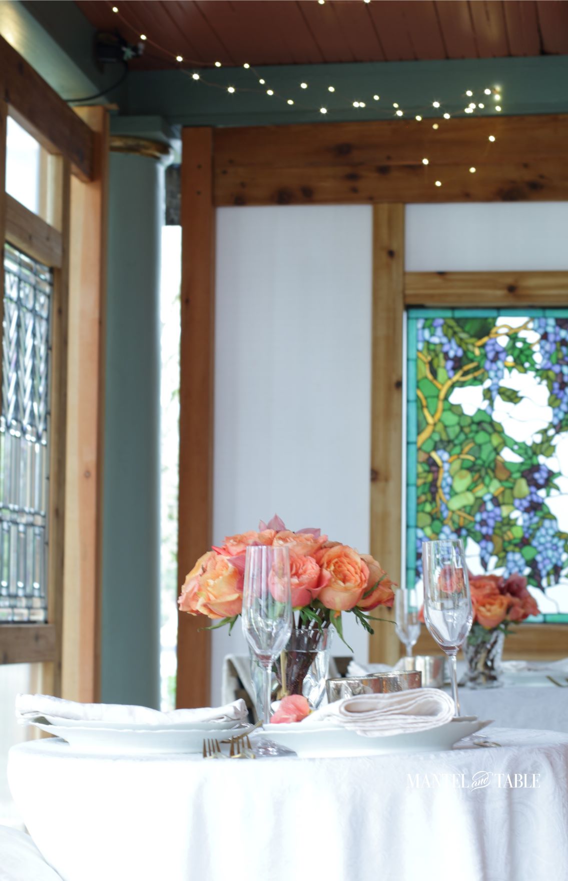 Socially distant dinner tables with white linen and peach flowers