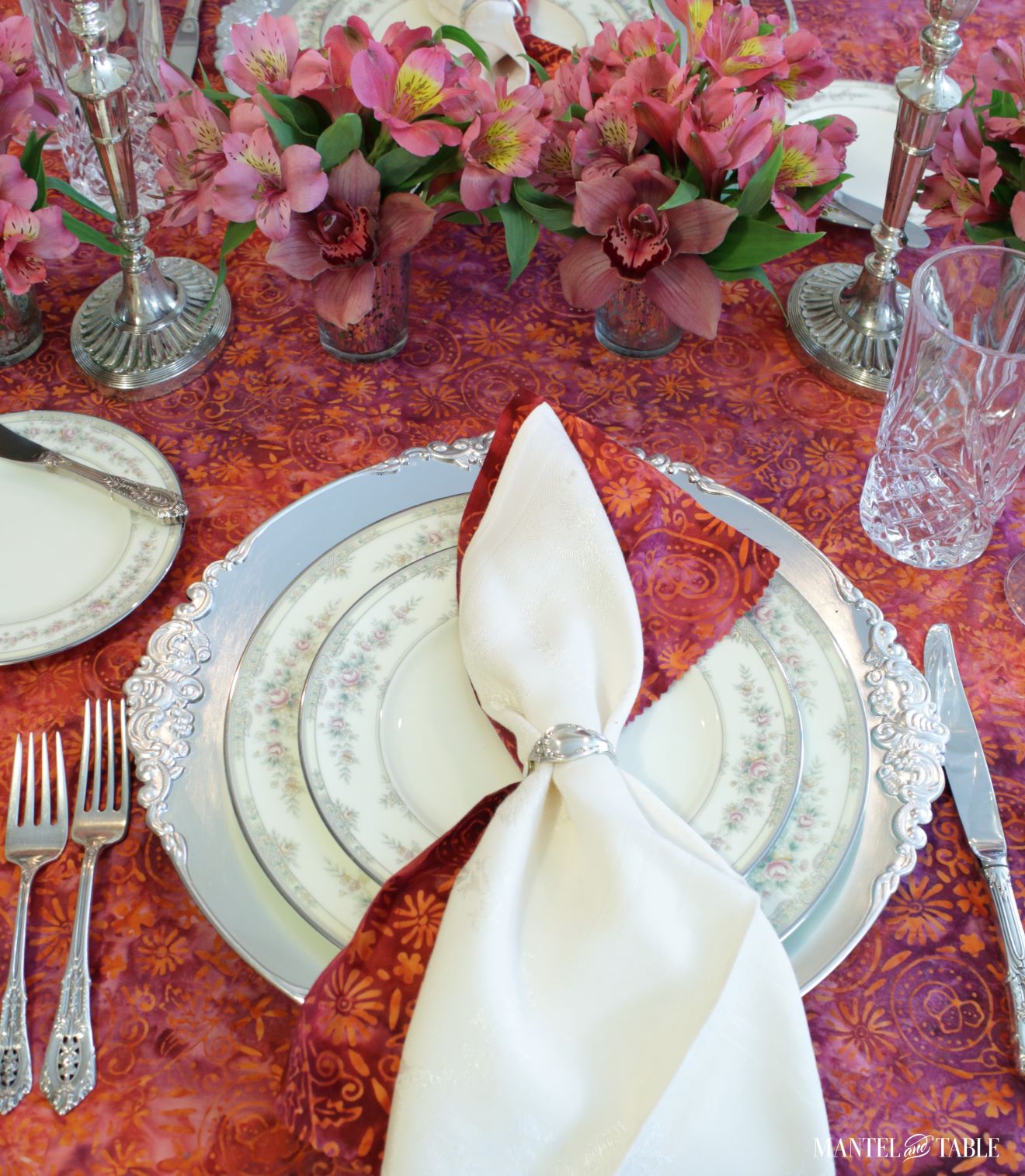 Bright tablescape - red, pink, and silver place setting from above