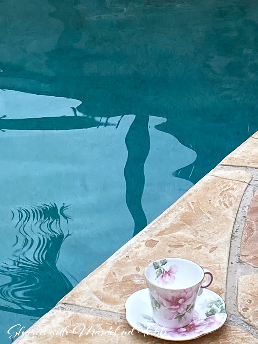 Pink and white flowered teacup poolside
