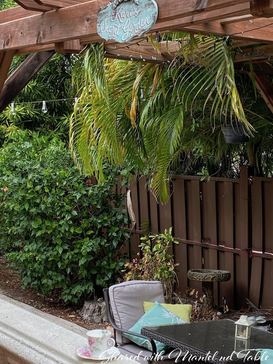 Charming Traveling Teacup sitting on concrete railing in tropical garden sitting area