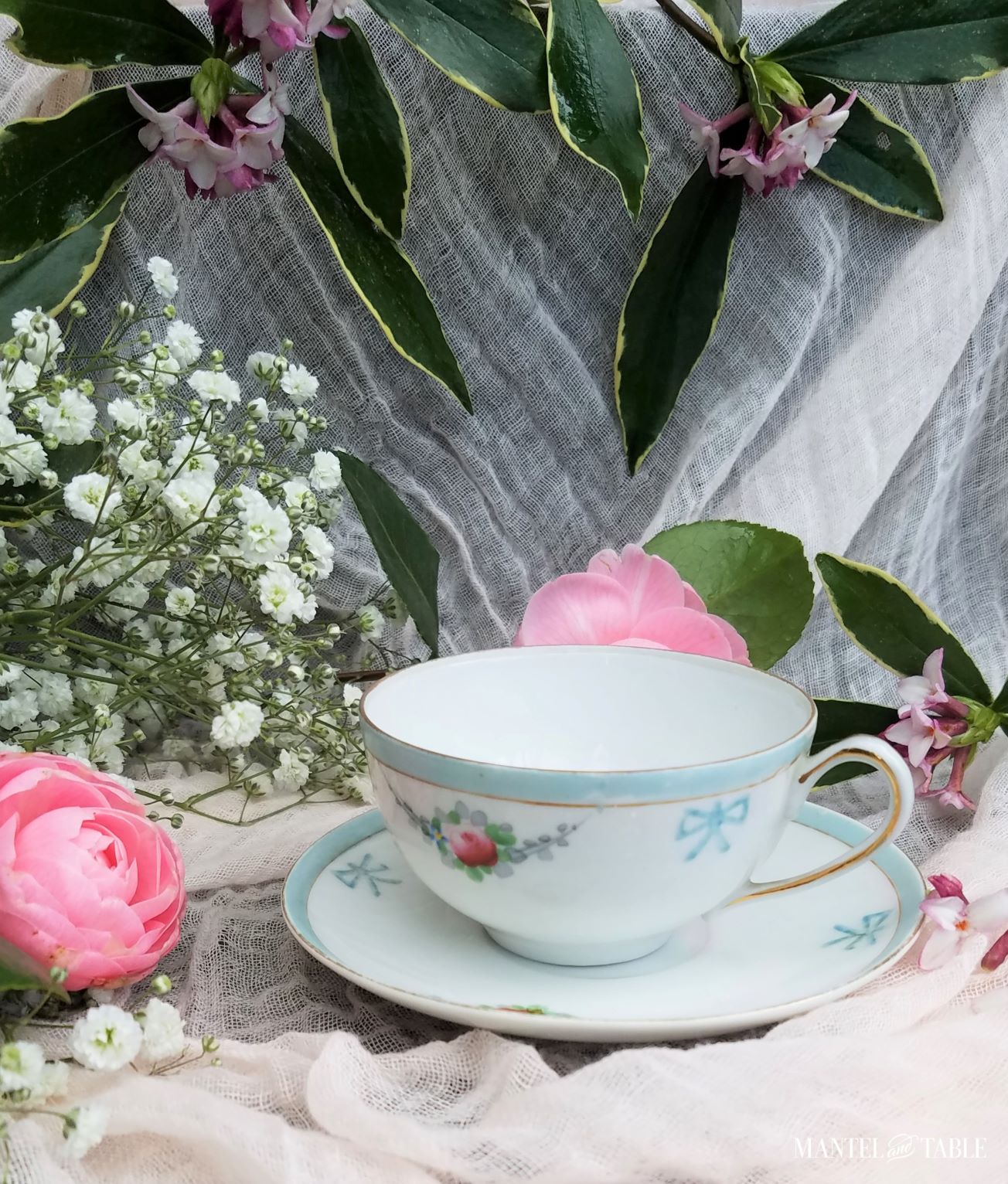 Darling teacup - baby blue bows and trim with pink flowers and gold rim.