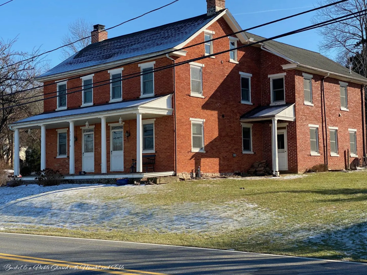 Lovely 200 year old red brick house with white trim and pillars on front porch