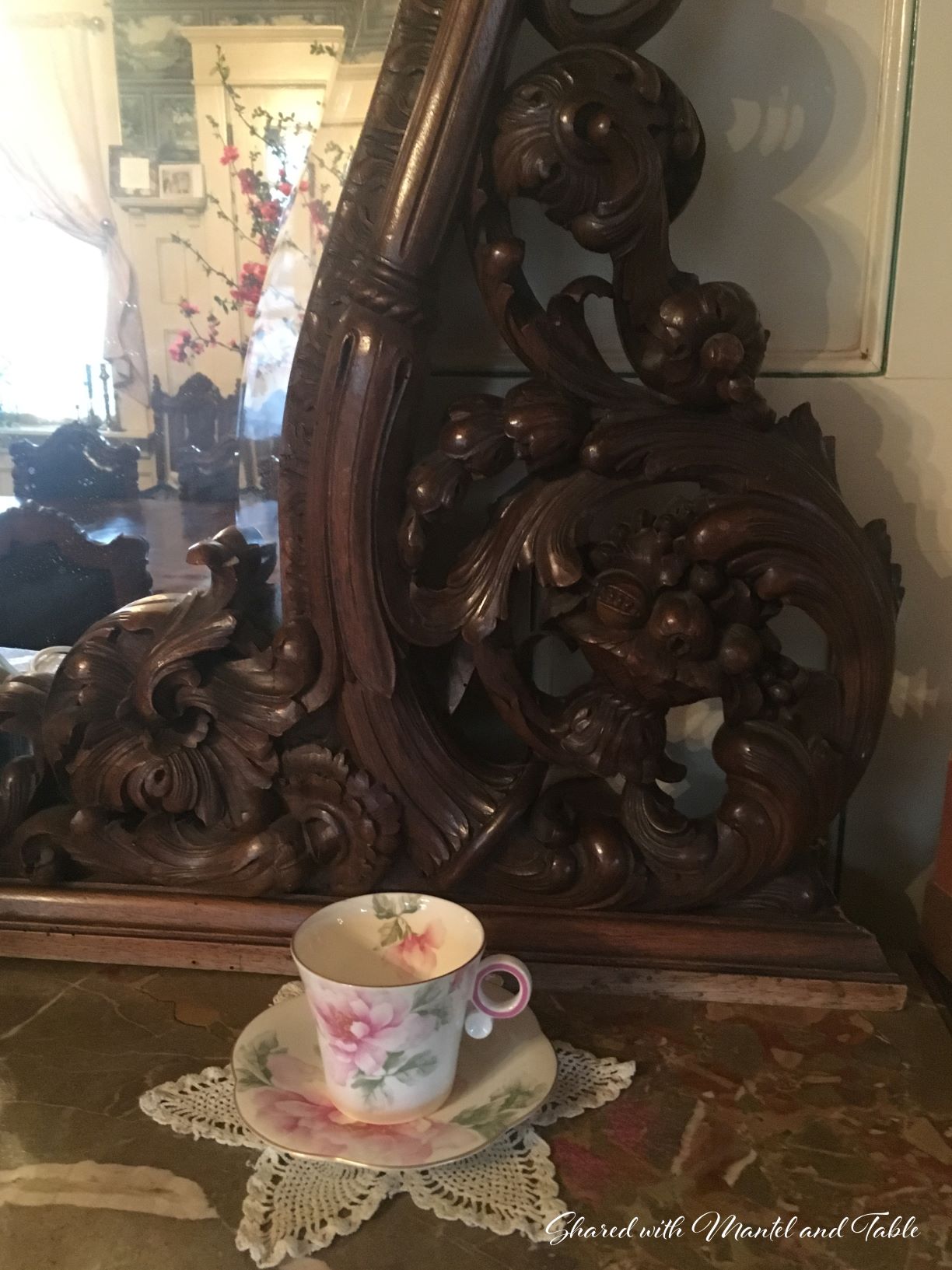 The Traveling Teacup on marble top of dark, intricately carved Italian buffet