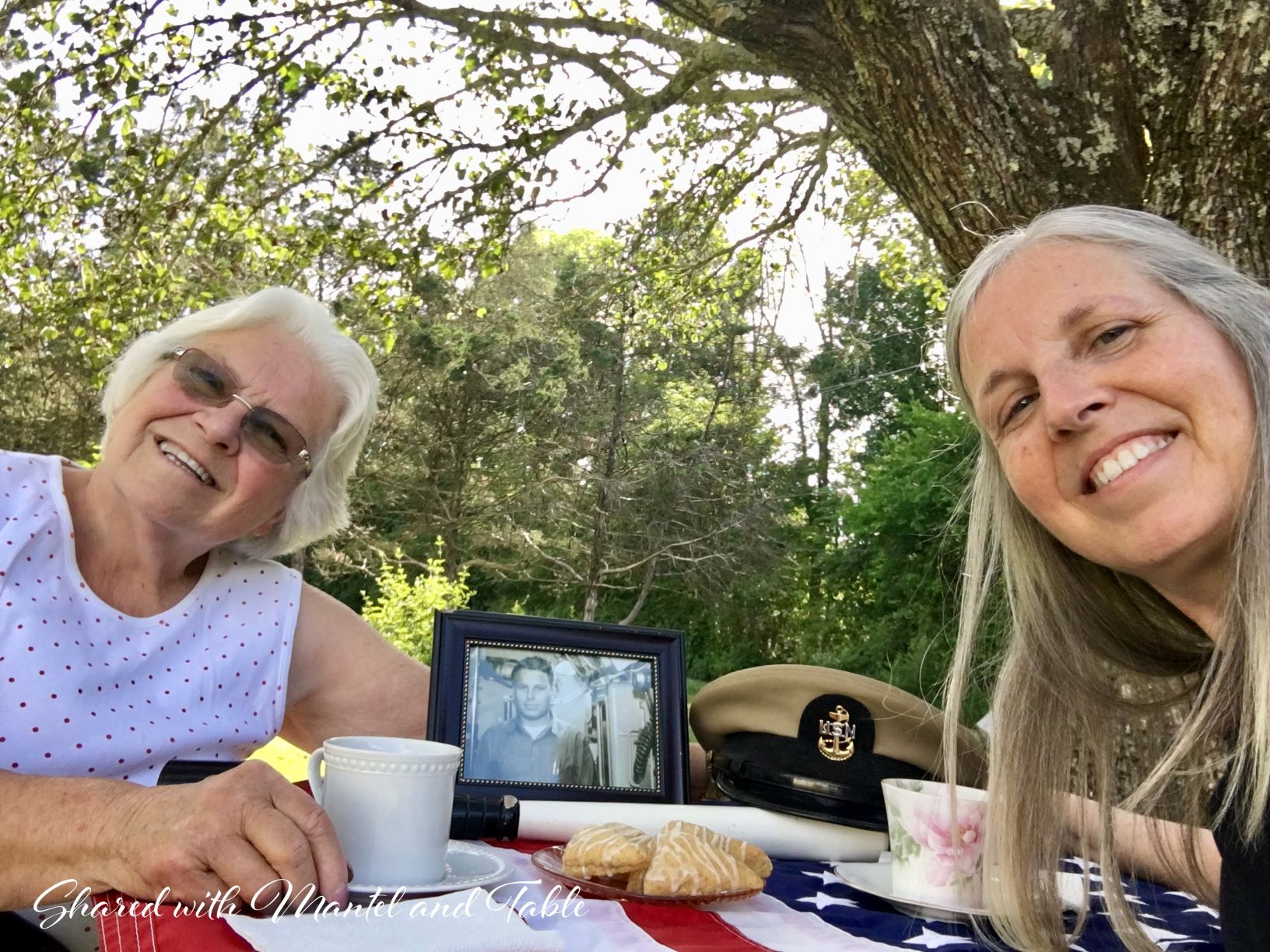 Mother and adult daughter leaning in across table on Memorial Day