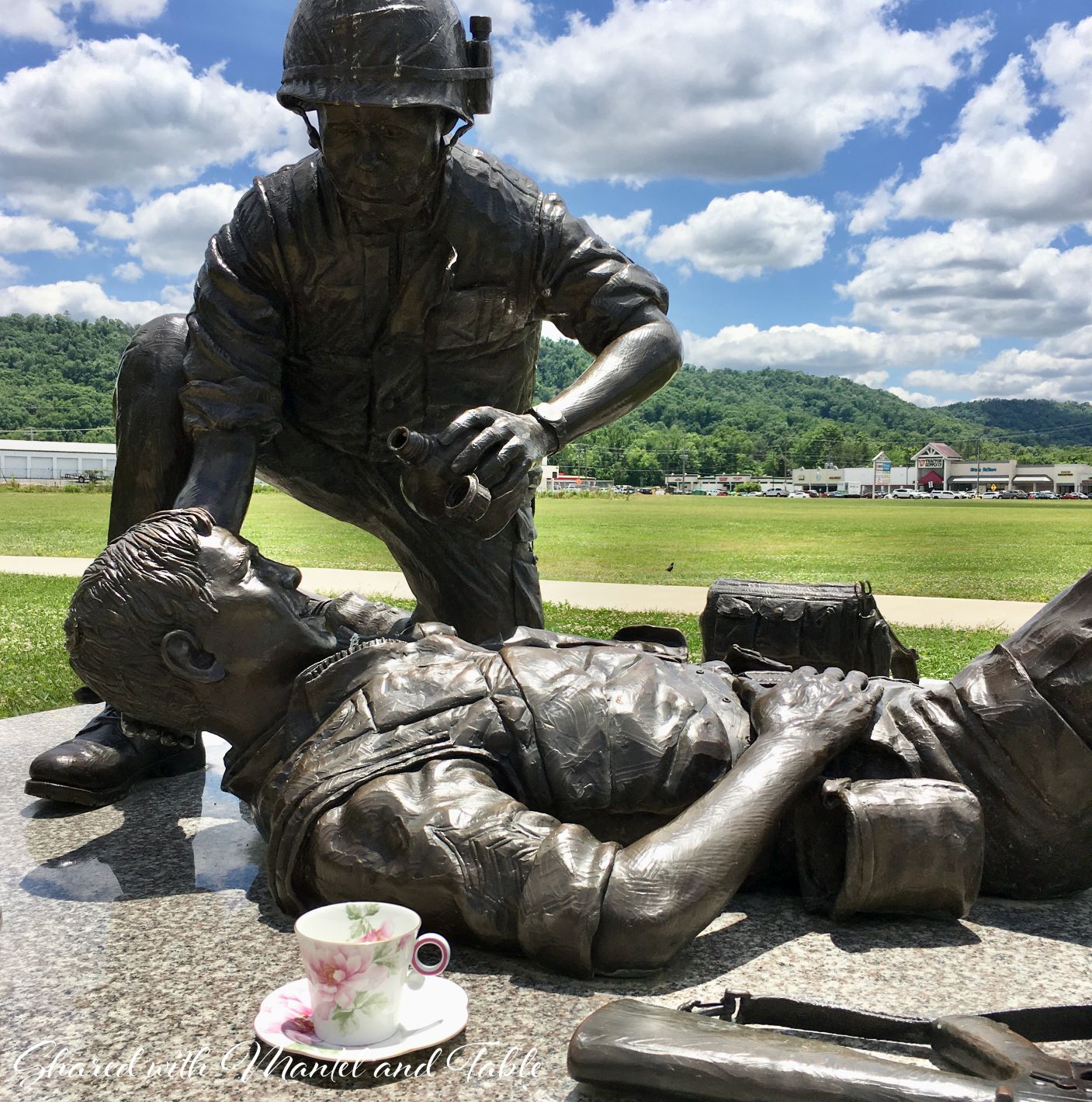 Memorial Day. Teacup on base of bronze statue of soldier and medic