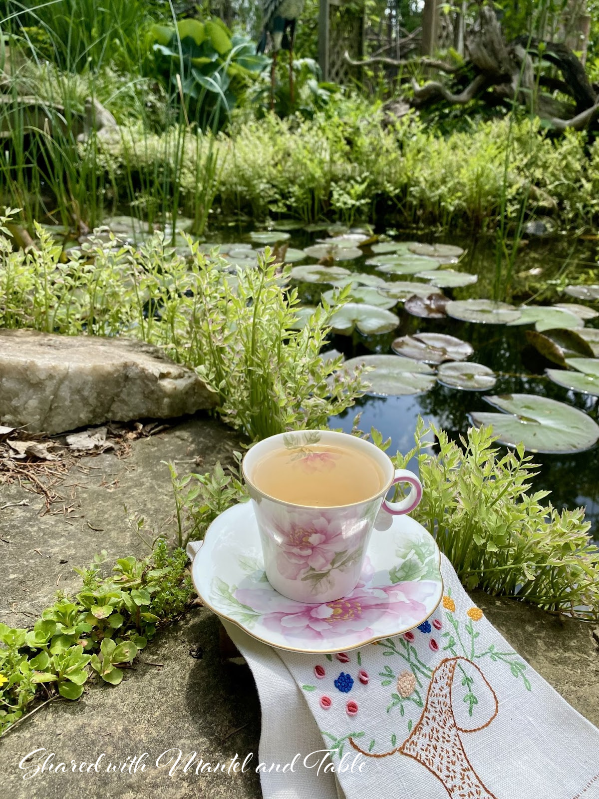 Closeup of teacup with lily pond in background