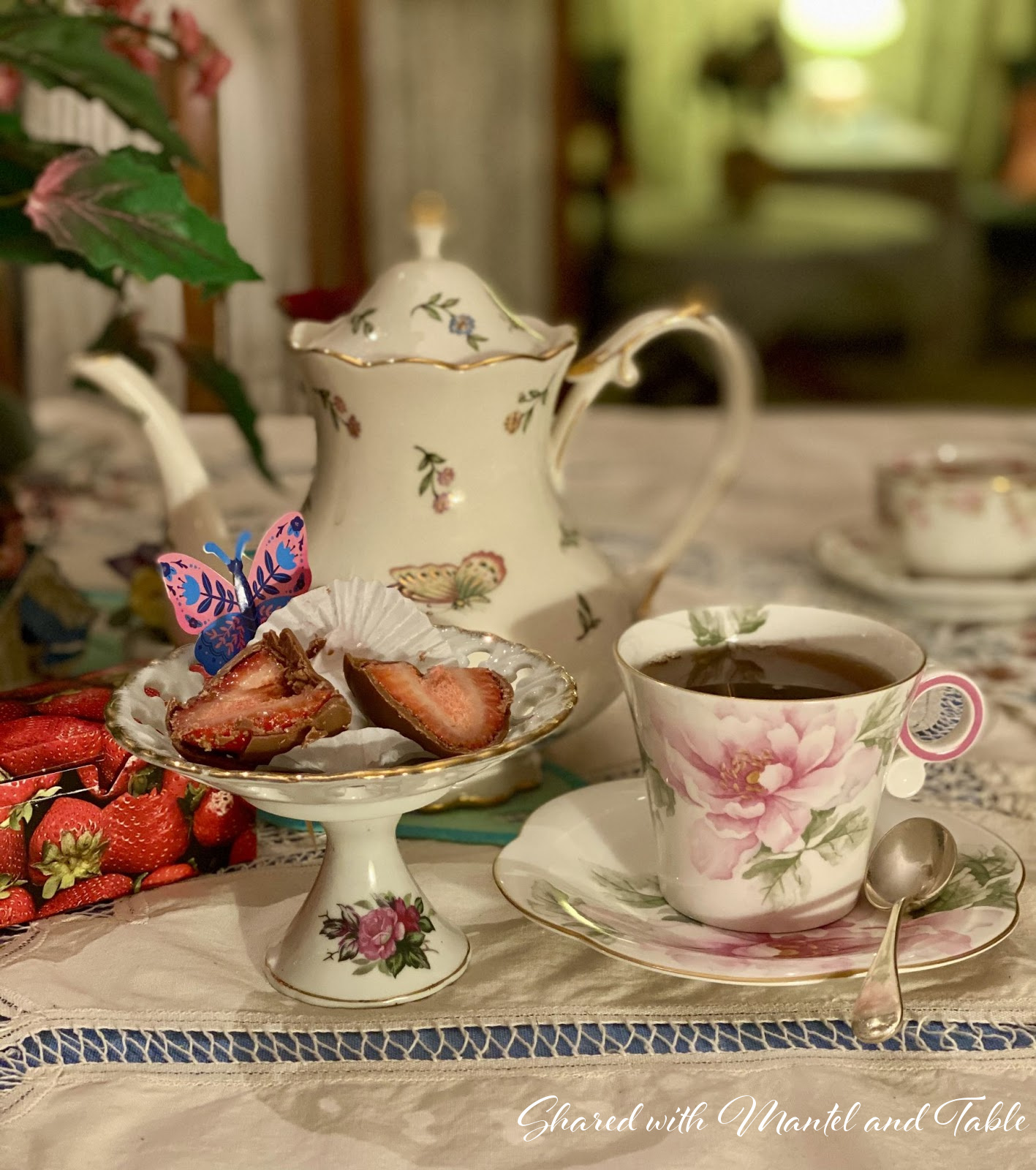 Teacup, teapot, and china stand with chocolate strawberries