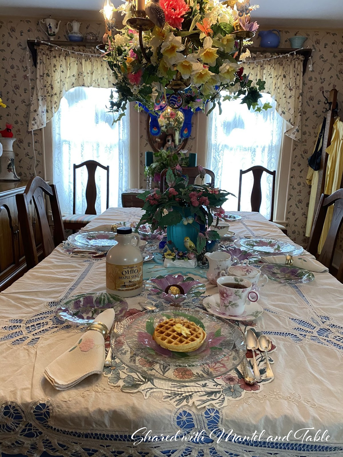 View of set breakfast table, plate of waffles and teacup