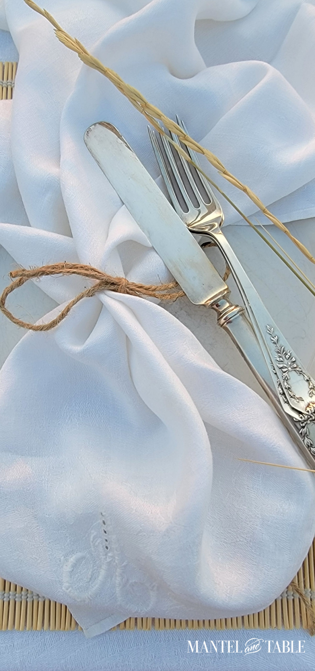 Closeup of silve knife & forks with white linen napkin