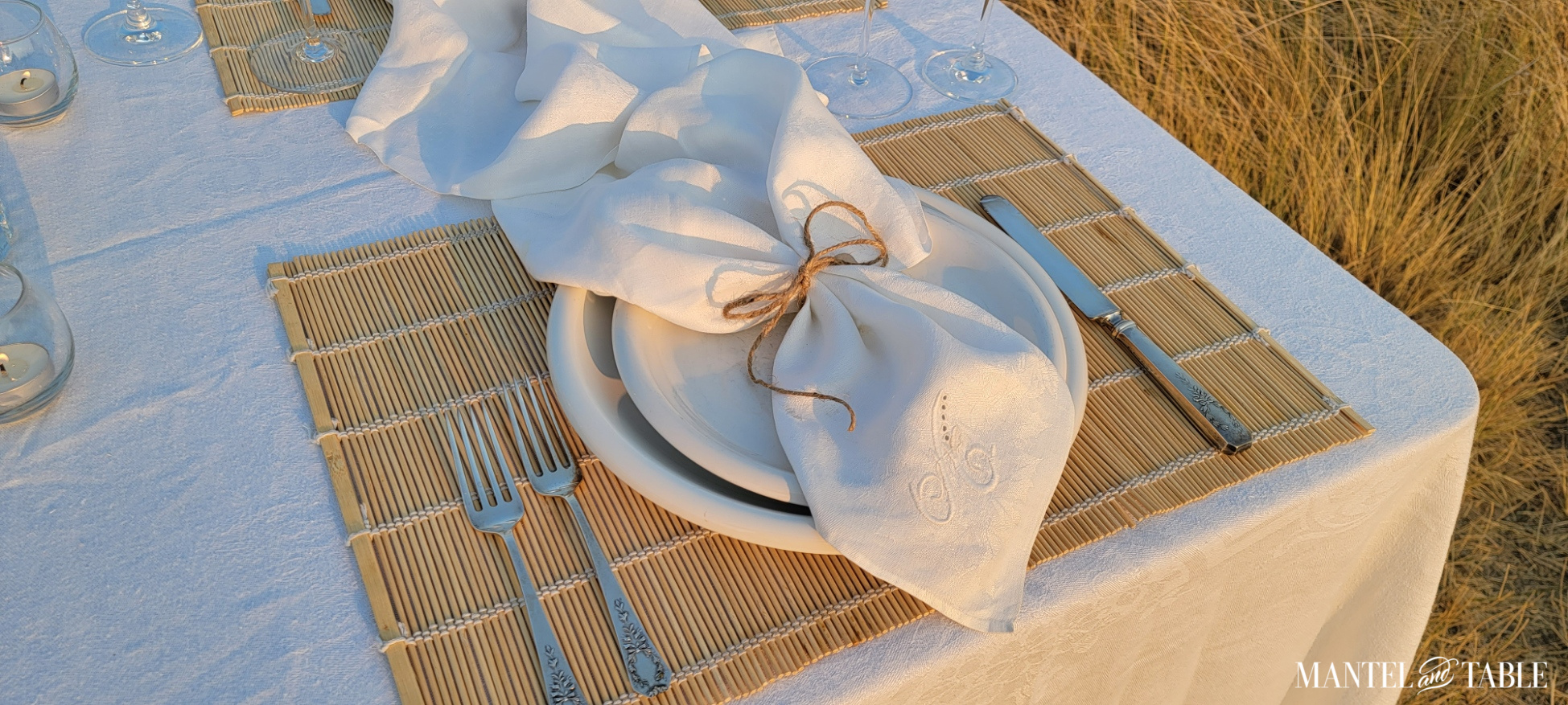 Top angle view of white, silver, and wheat-colored place setting
