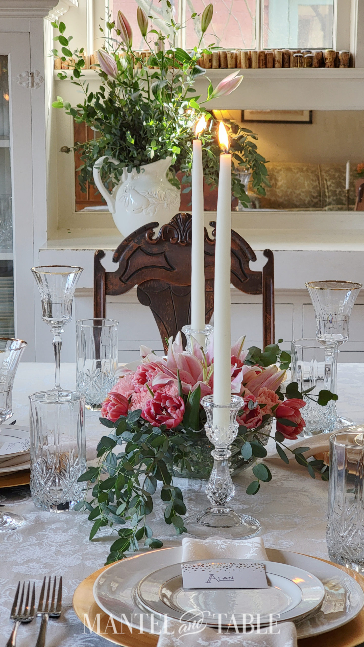 Tall white taper candles with pink centerpiece in table setting