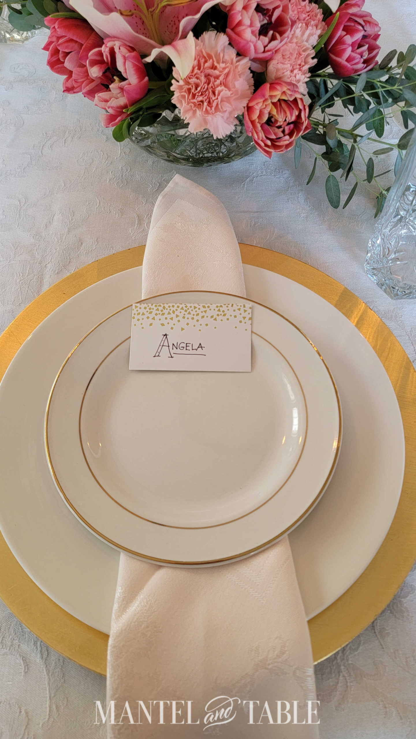 Top view of gold place setting and pink centerpiece