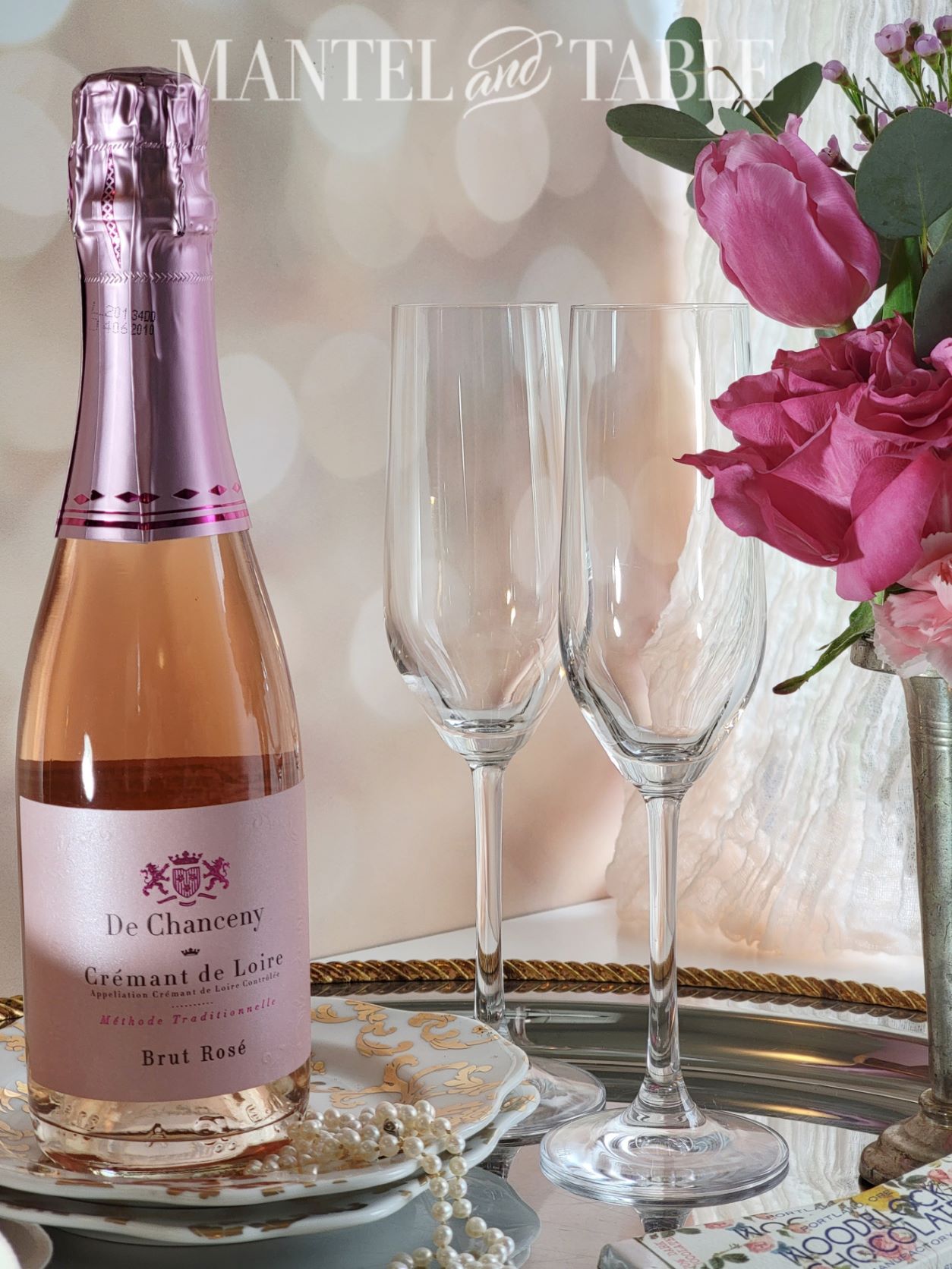 Pink champagne, glasses, and flowers