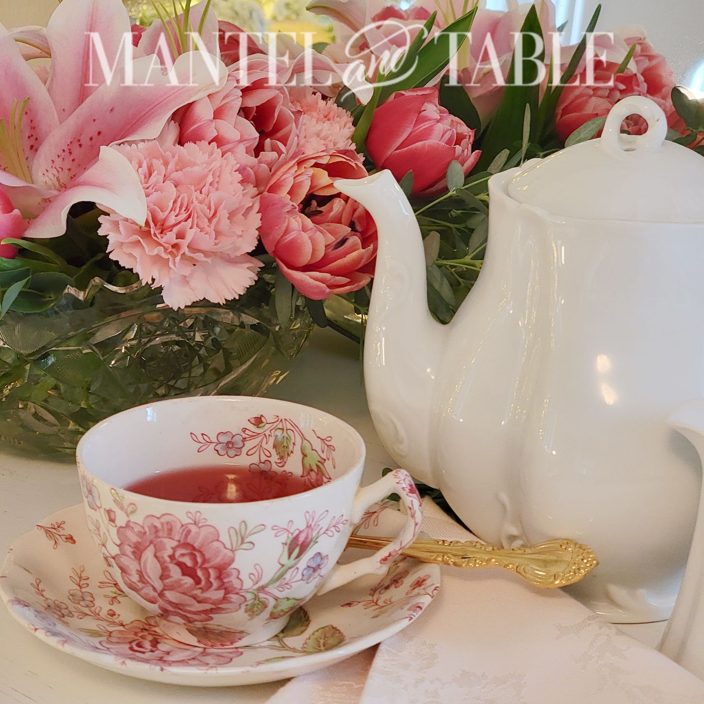 Pink flowered teacup with white teapot and pink flowers