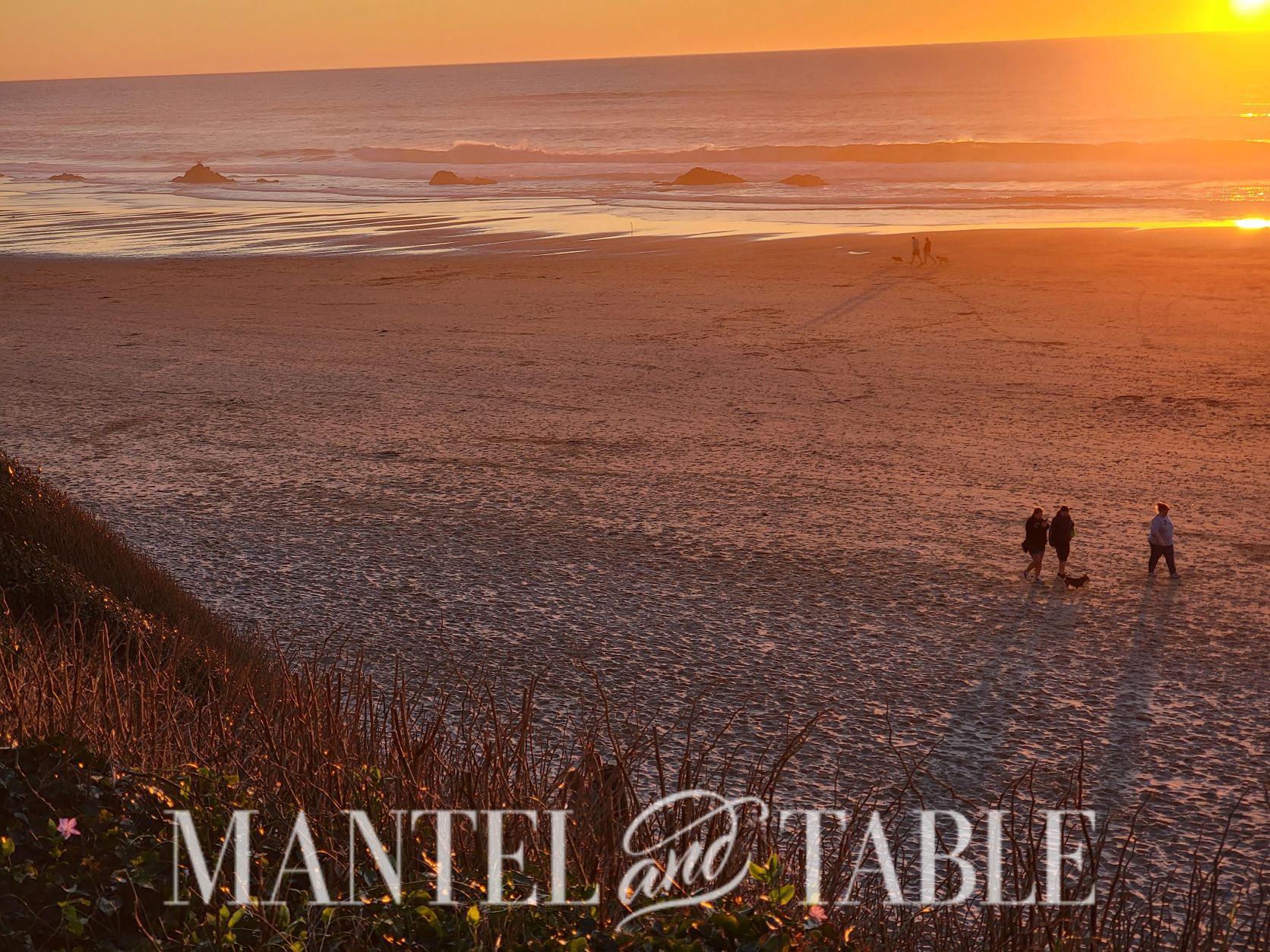 People walking on the beach at sunset