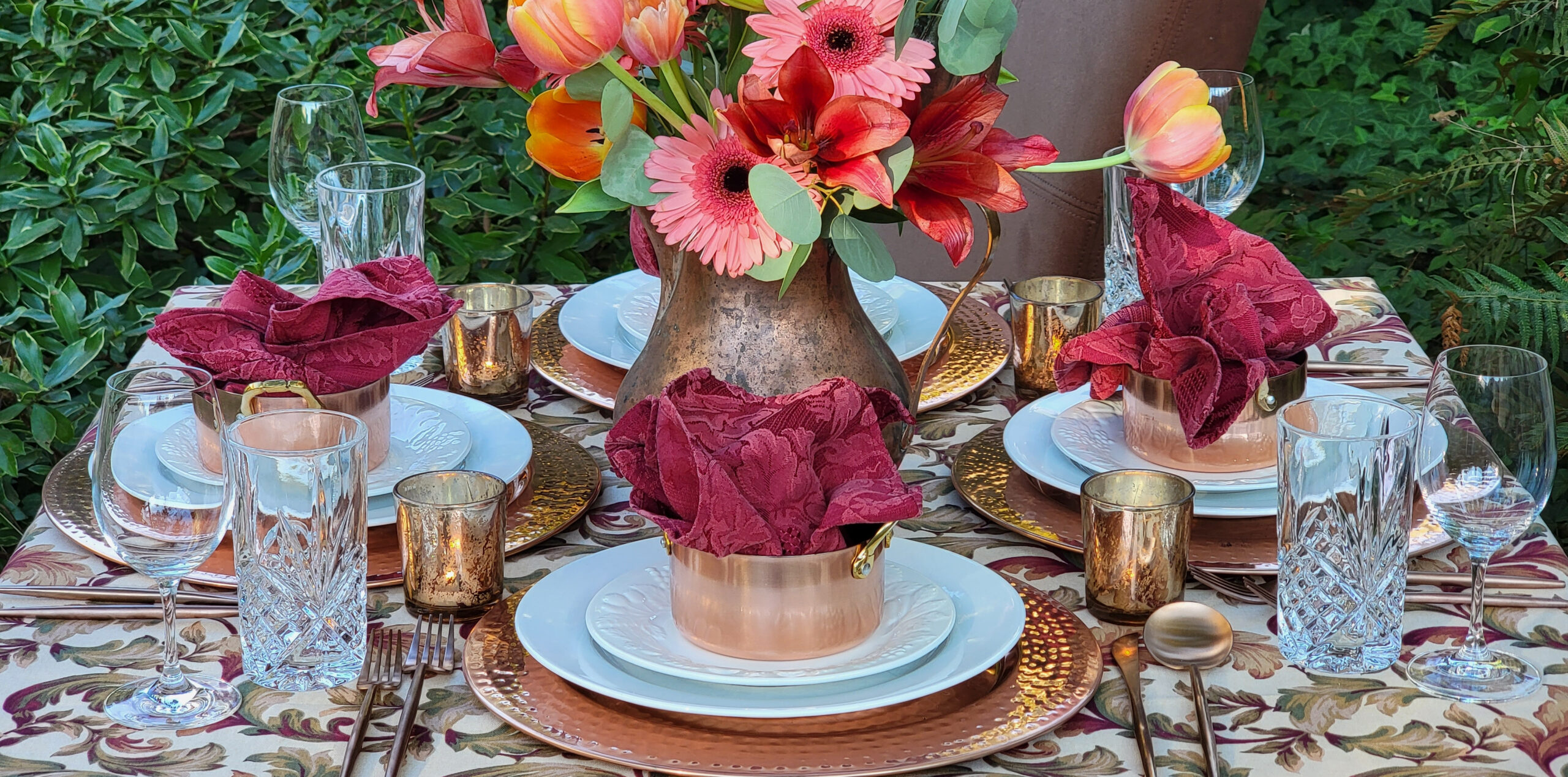 Tablescape with bright pink flowers and copper