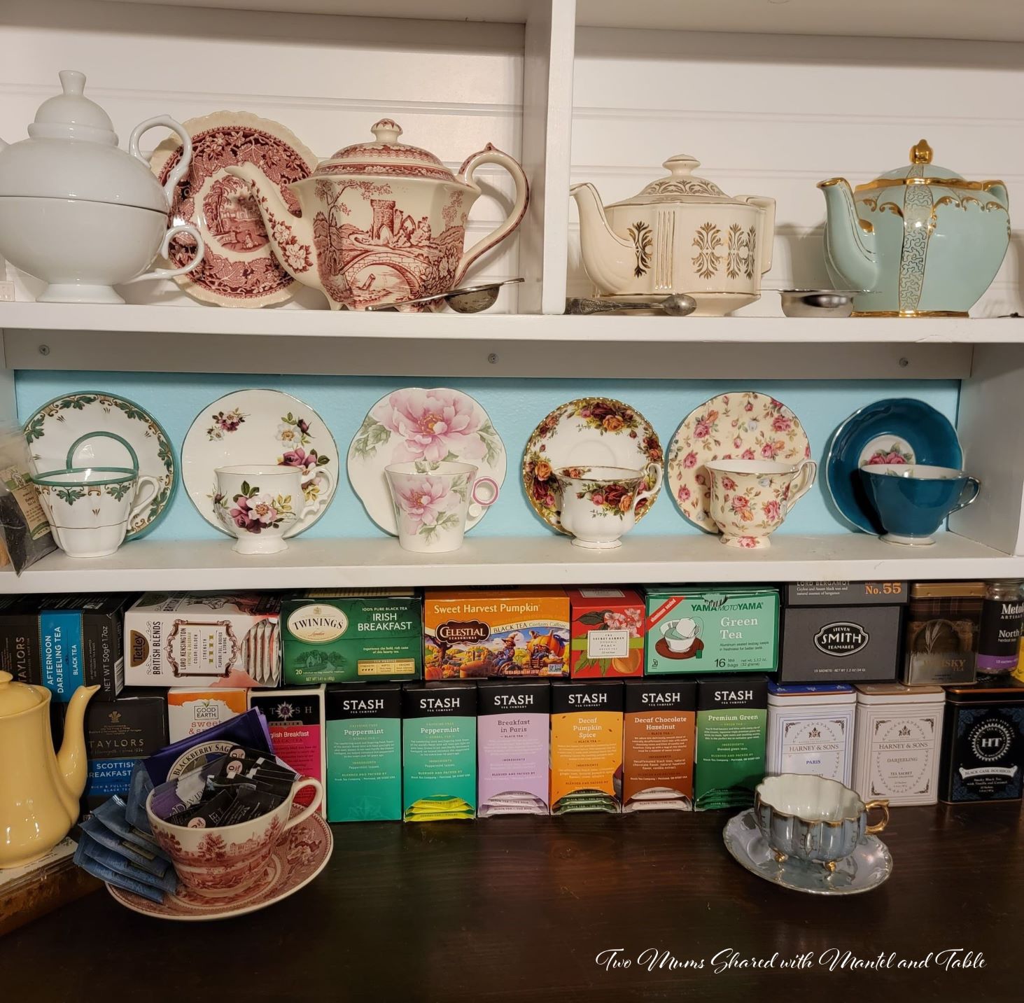 teacups on a shelf, tea boxes underneath on counter