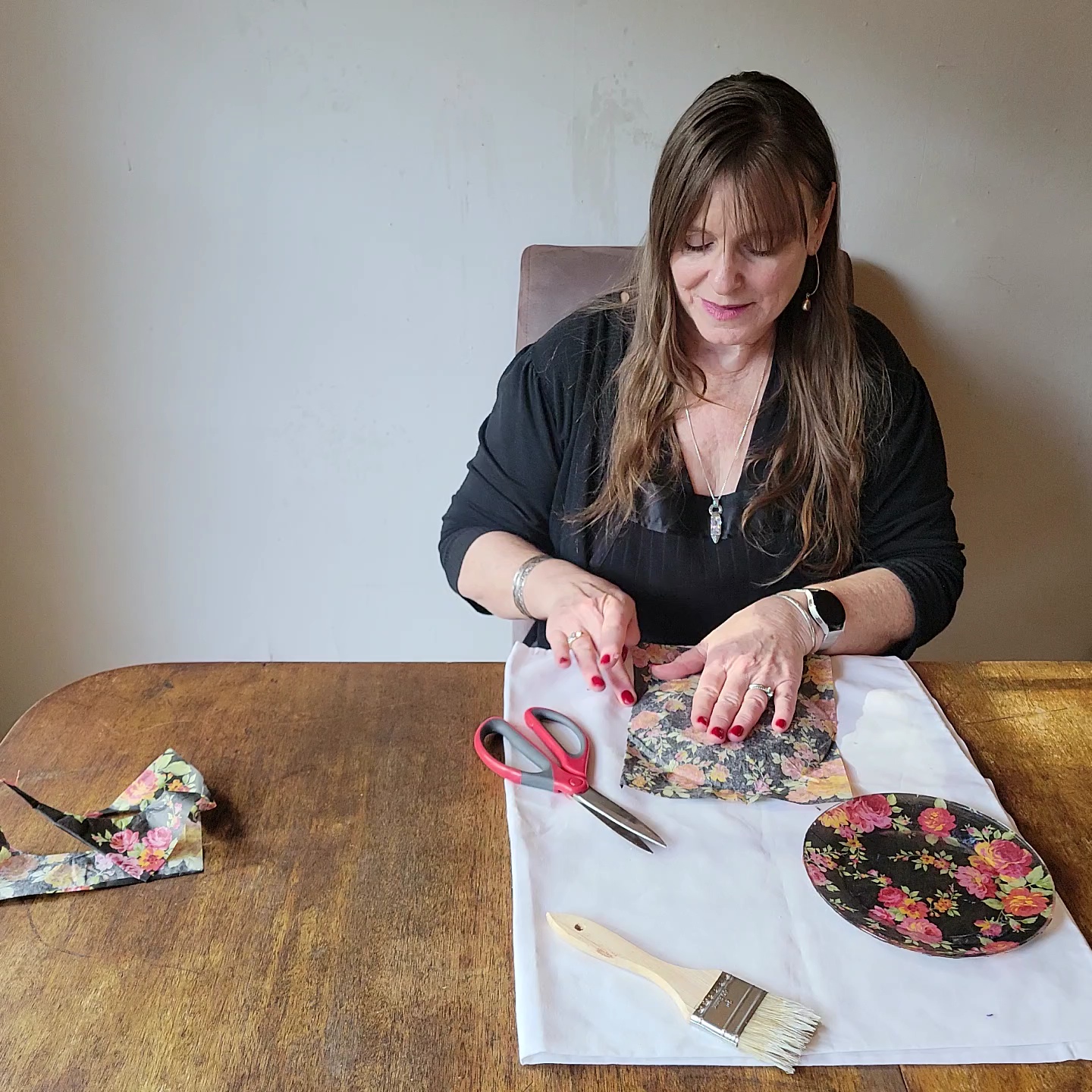 Two table setting problems solved! Woman smoothing tissue paper over a plate.