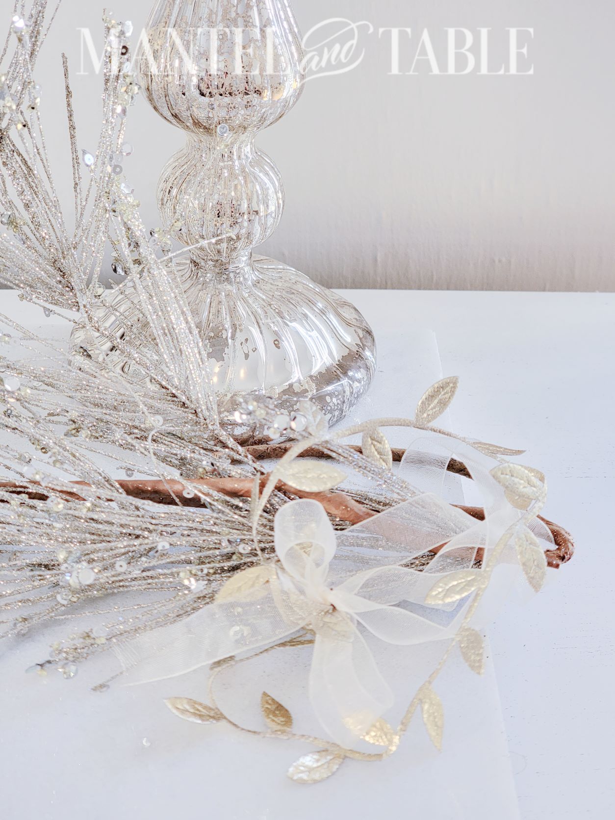 Winter tray decor - closeup of end of branch with gold leaf ribbon