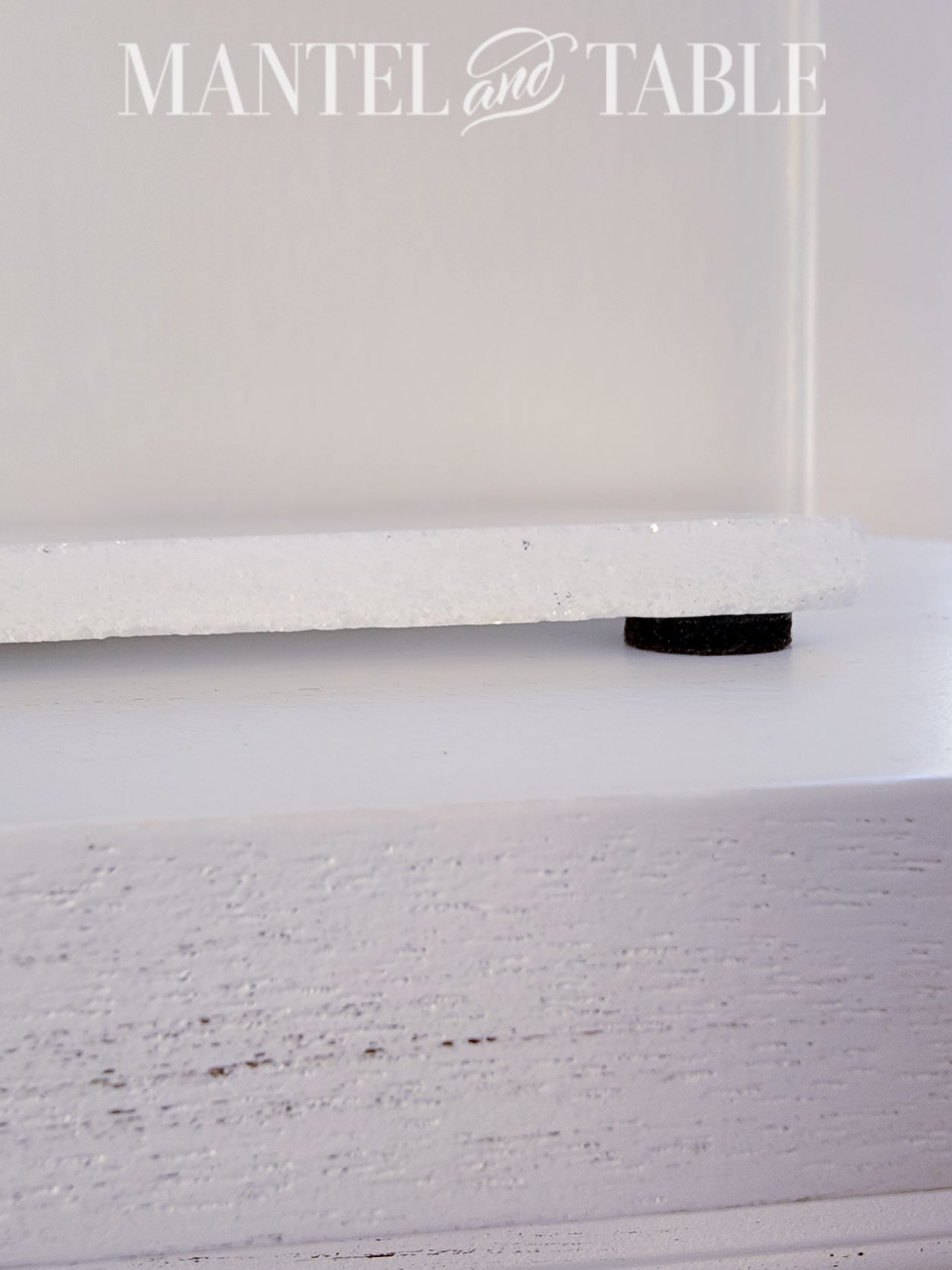 White marble tile with felt pad on the underside