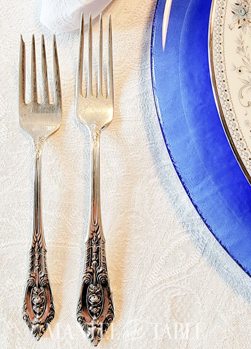 Closeup of silver flatware in a blue table setting