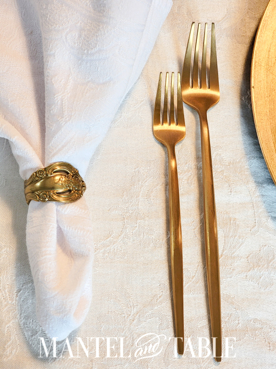 Gold forks closeup on white tablecloth