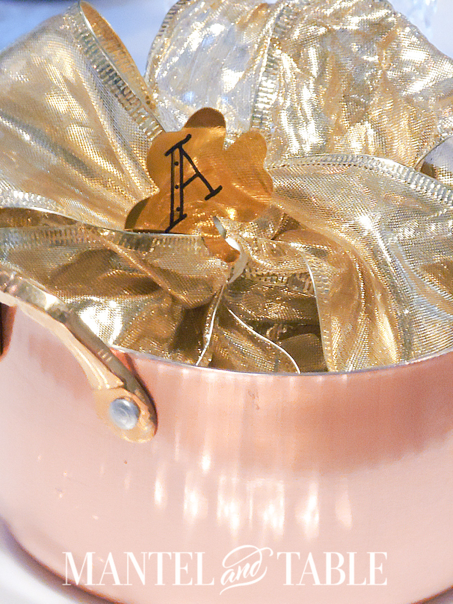 Copper dutch oven with gold ribbon and initial place card