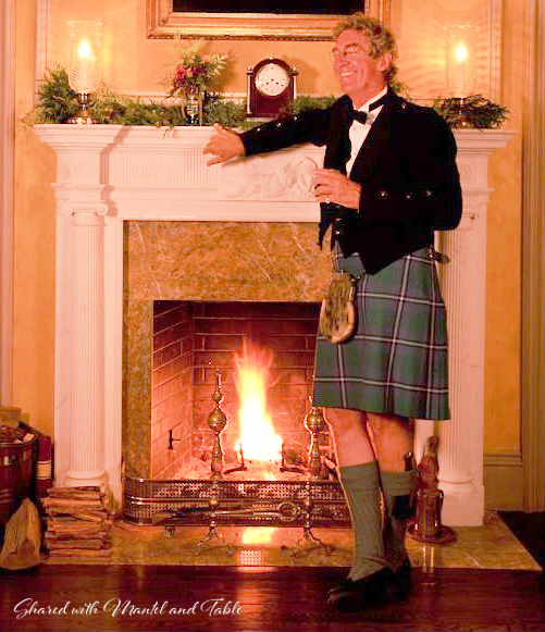 Smiling man in kilt leaning on fireplave