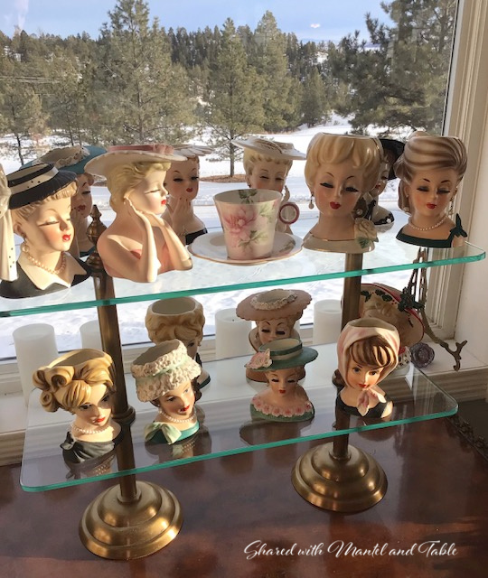 Teacup on the ranch with a collection of lady head vases