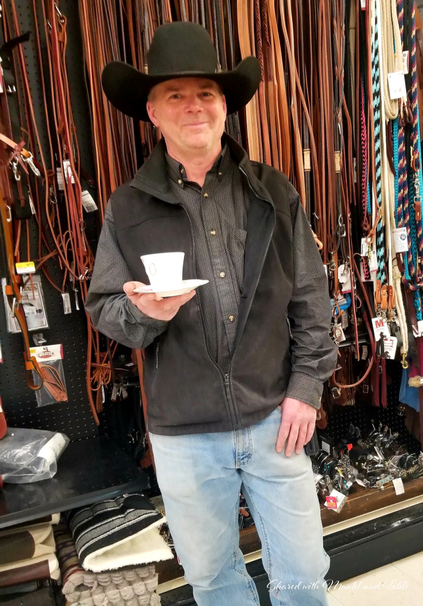Man in cowboy hat holding a pink flowered Teacup