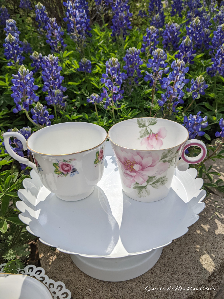 Two teacups on a white stand in the garden