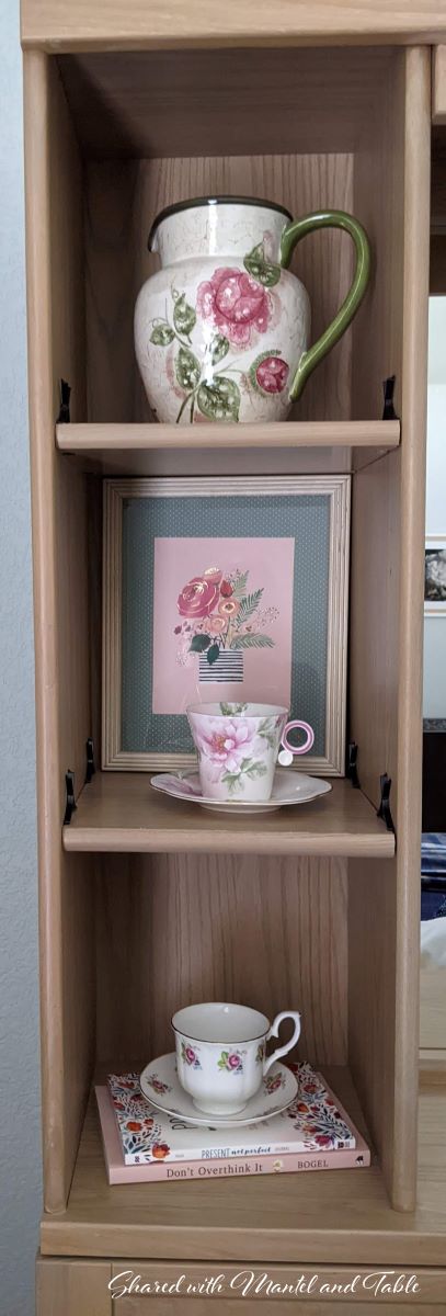 Teacups and pitcher on three-tiered shelf