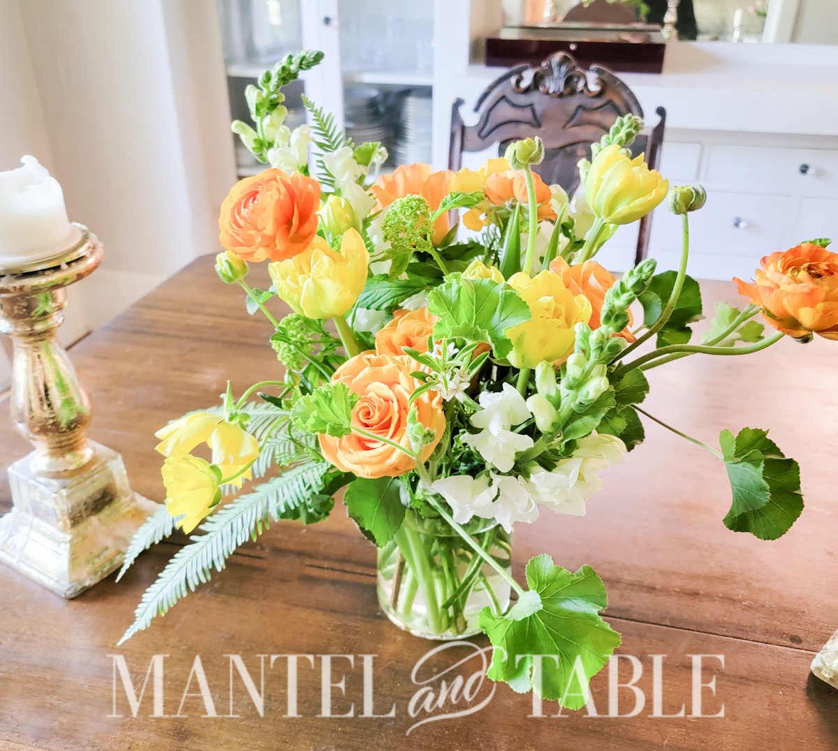 Peach and yellow flower arrangement on dining room table