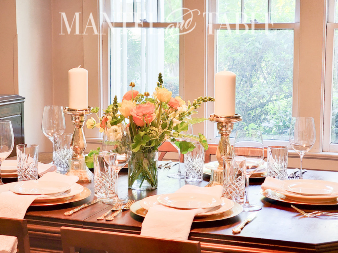 White and gold table setting with peach and yellow flower centerpiece
