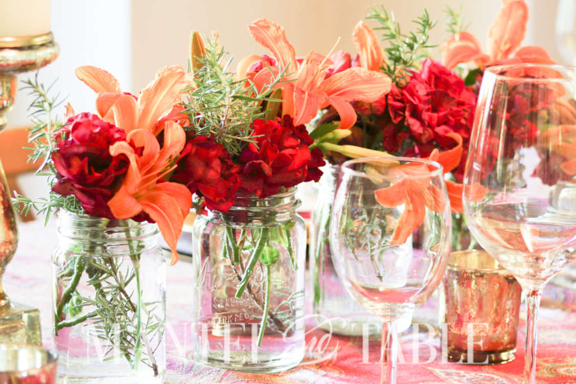 Centerpiece of Red roses, orange lilies in mason jars