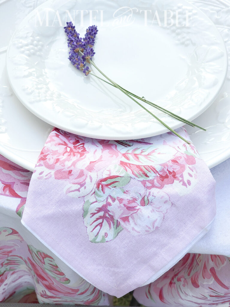 Closeup of lavender sprigs on white plates with pink rose napkin