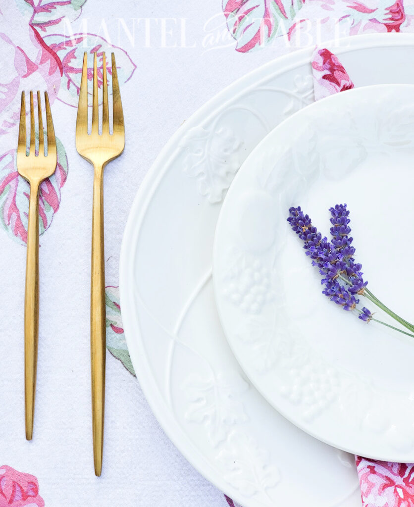 lavender bouquet tablescape closeup of gold flatware beside white plates