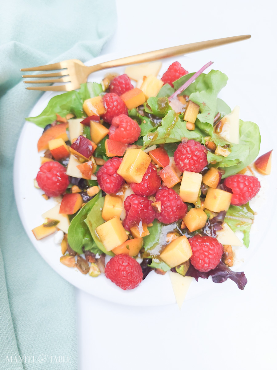 Summer Salad with raspberries on white plate, green napkin