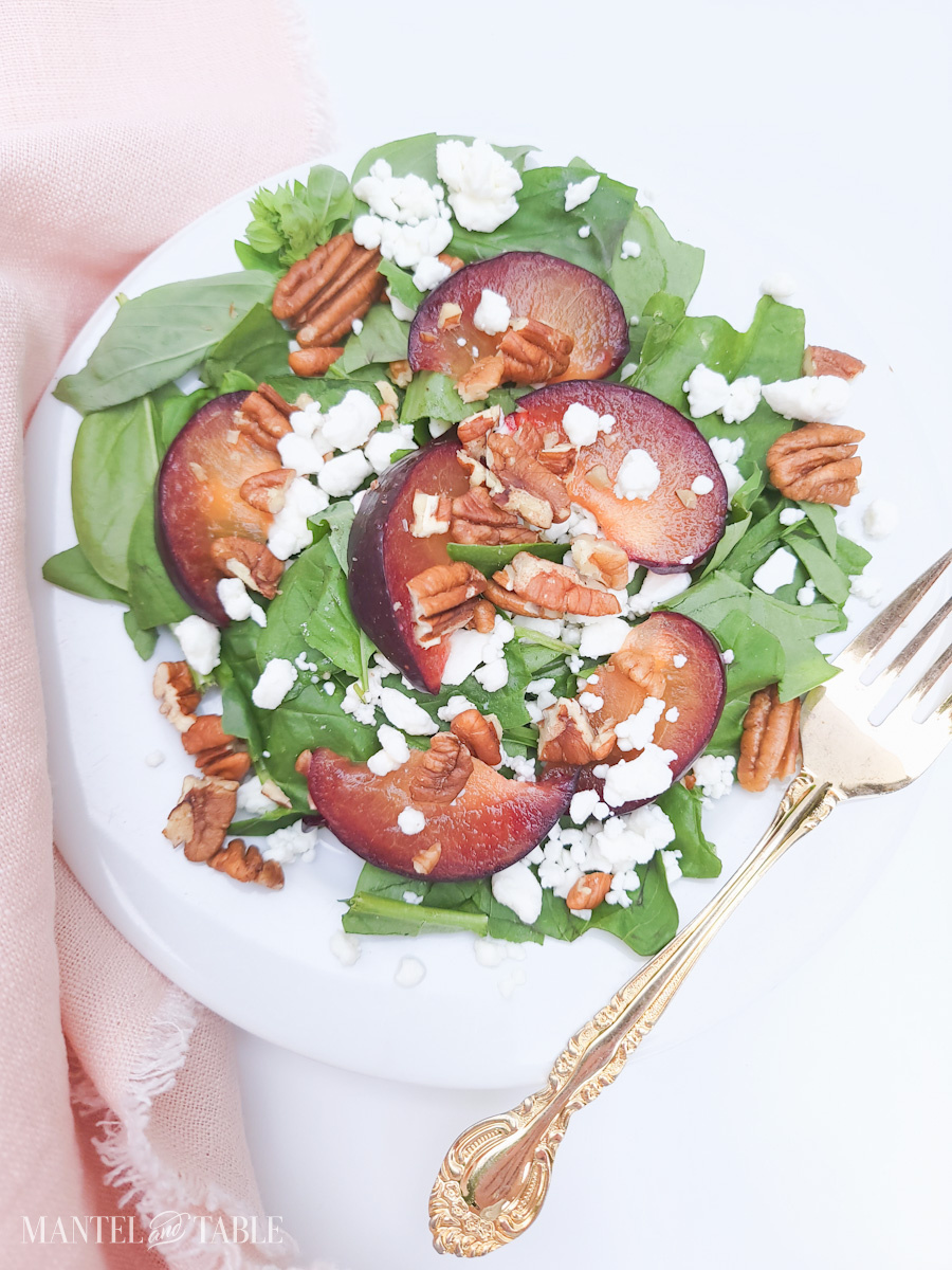 Summer Salad with plums on white plate, pink napkin