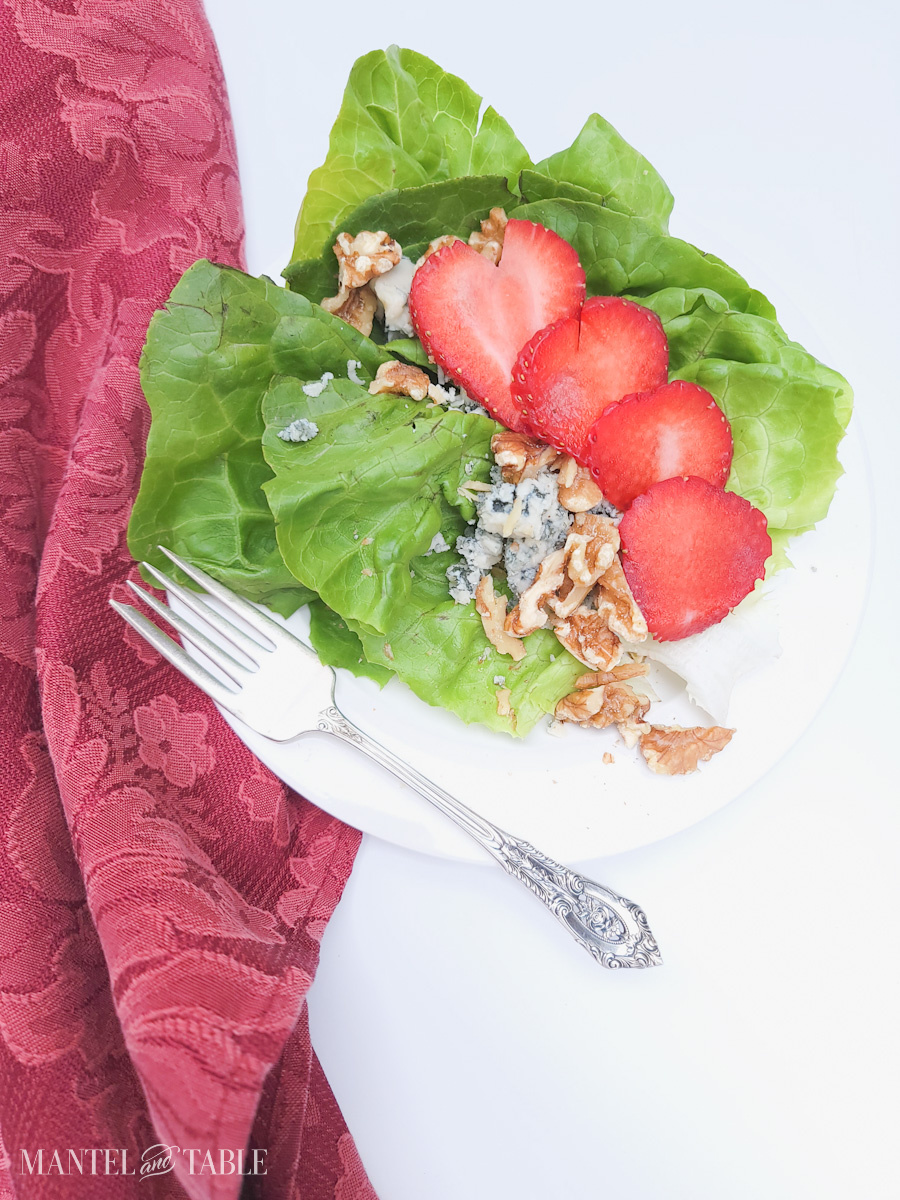 Summer Salad with strawberries on white plate, red napkin