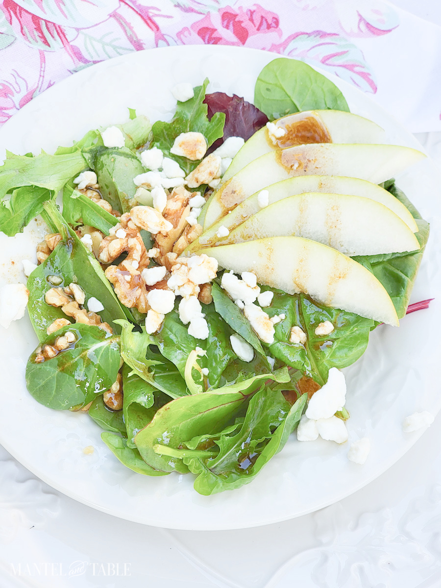 Summer Salad with pear on a white plate, pink floral napkin
