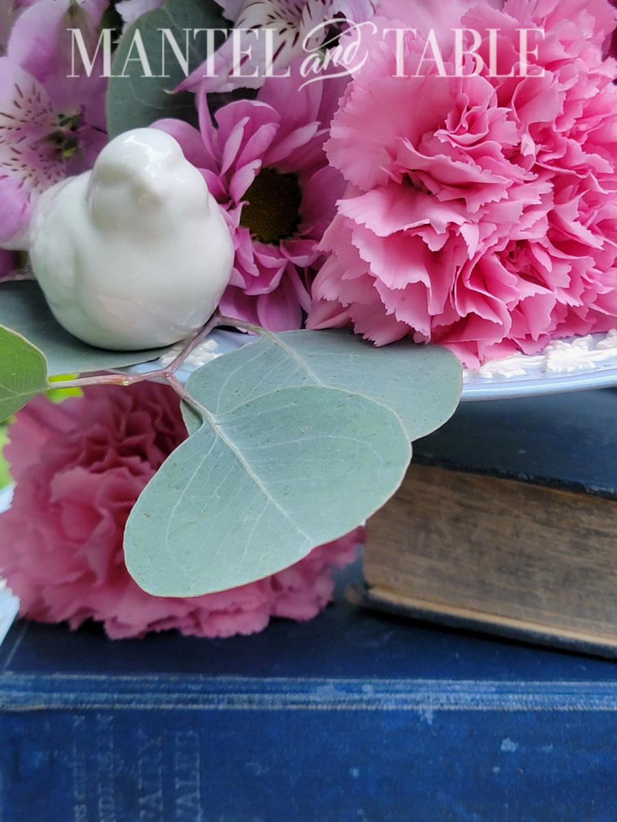 Closeup of white bird figuring on blue tray with pink flowers